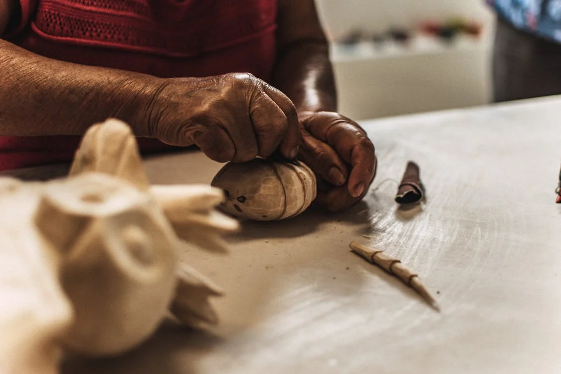 Close-up of a craftsman's hands working on a piece of wood